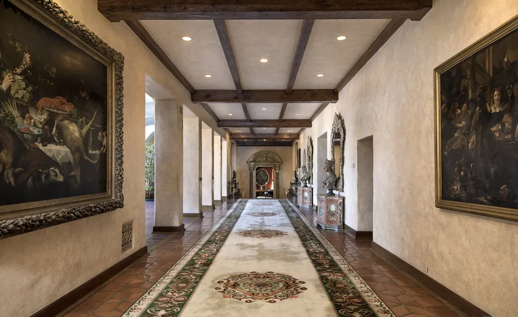 The Hearst Estate in Beverly Hills: A Historic Landmark Where Hollywood Legacy Meets Market Reality 9 The Hearst Estate in Beverly Hills featuring gallery hallway with exposed wood beams, terracotta floors, and classic art collection