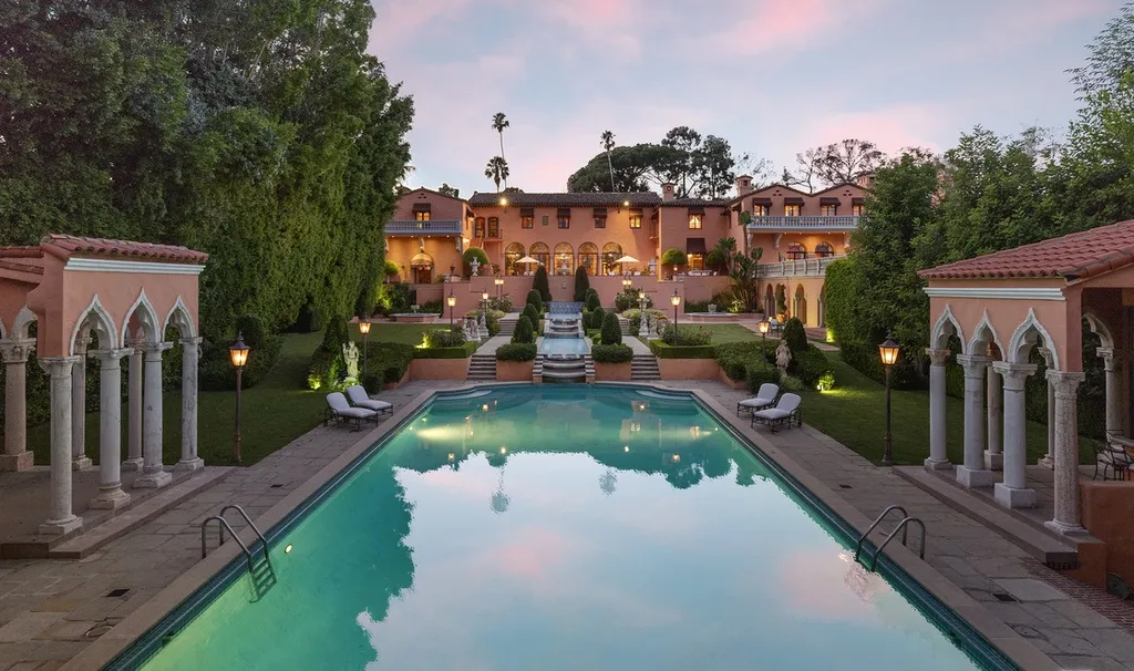 The Hearst Estate in Beverly Hills: A Historic Landmark Where Hollywood Legacy Meets Market Reality 2 The Hearst Estate in Beverly Hills featuring grand swimming pool terrace with cascading stairs and Mediterranean style architecture at sunset