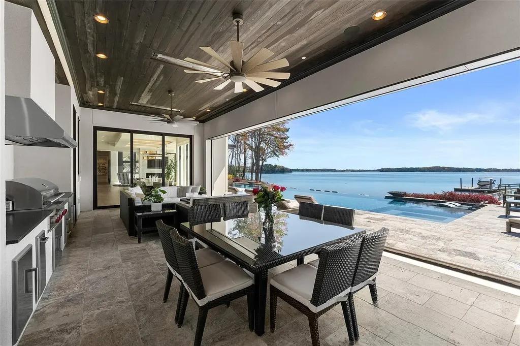 Lake Norman Estate Blends Architectural Precision With Private Waterfront Living 11 Covered outdoor dining area with lake view and infinity pool at Lake Norman luxury home in Cornelius NC