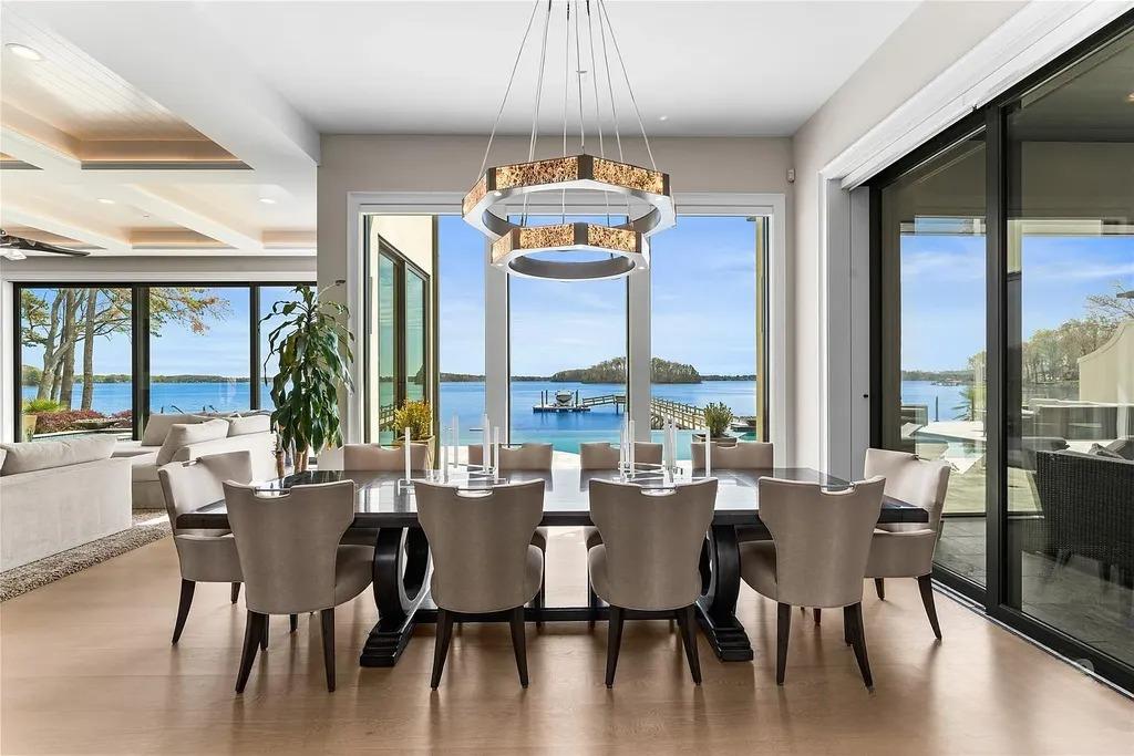 Lake Norman Estate Blends Architectural Precision With Private Waterfront Living 7 open plan dining area with modern lighting and large glass doors in a luxury home near Lake Norman in Cornelius North Carolina