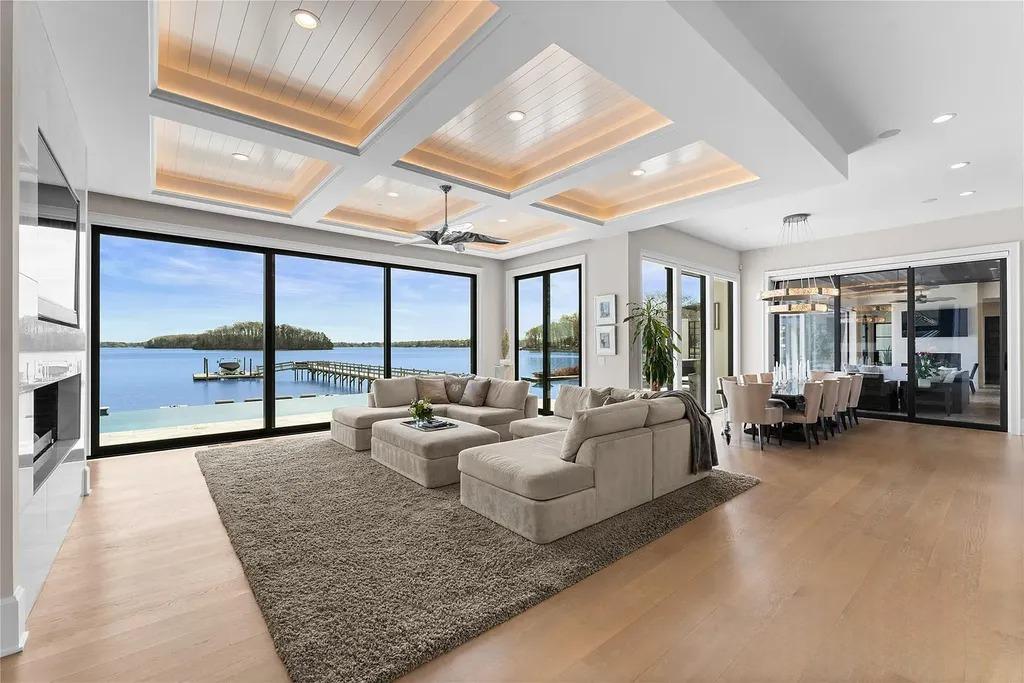 Lake Norman Estate Blends Architectural Precision With Private Waterfront Living 3 open plan living room with large glass windows overlooking Lake Norman in a modern luxury home