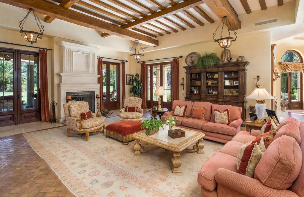 Villa Firenze: One of the Largest Private Estates in Beverly Hills 8 family living room inside Villa Firenze Beverly Hills with fireplace exposed beams and seating area