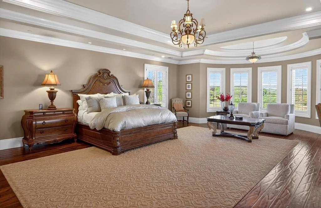 Inside a $13.5 Million Mediterranean Mansion in Ruby Hill, Pleasanton 11 Primary bedroom suite at 1515 Germano Way featuring tray ceilings, hardwood floors, sitting area, and panoramic valley views.
