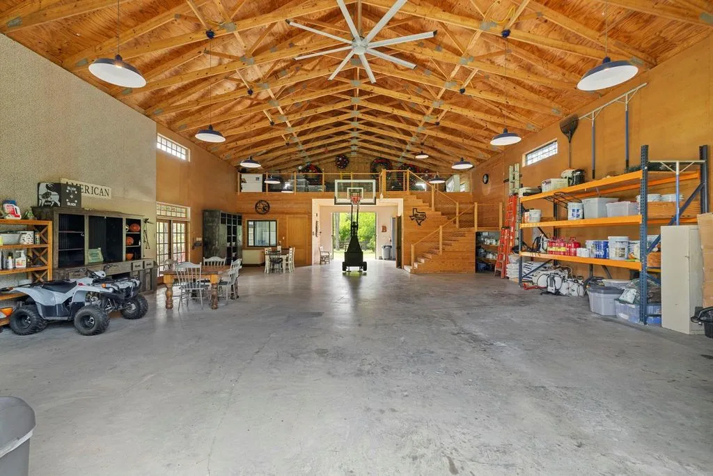 A Multigenerational Texas Estate in Tomball Lists for $6,000,000 With Resort Grounds and Private Guest Residence 11 Luxury climate-controlled barn interior with basketball hoop and entertainment space at 5 Willowcreek Ranch Dr in Tomball TX