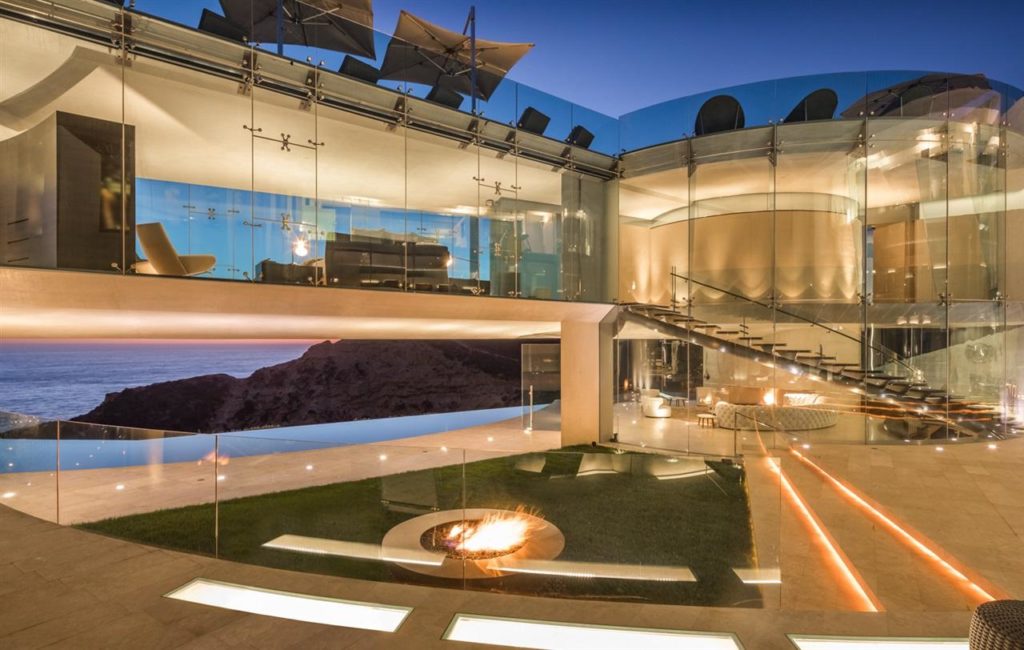 Modern Mansions in California: Where Design, Power, and Global Wealth Converge 7 modern interior at Razor House with glass walls ocean view and outdoor fire feature
