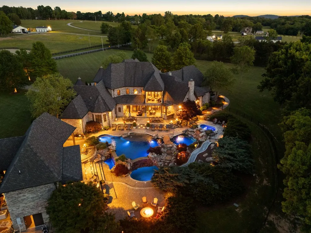 Inside a $12 Million Tennessee Estate With 62 Private Acres and Resort Amenities 2 Aerial evening view of a luxury estate in College Grove Tennessee featuring a resort-style pool complex, outdoor lighting, and expansive private grounds