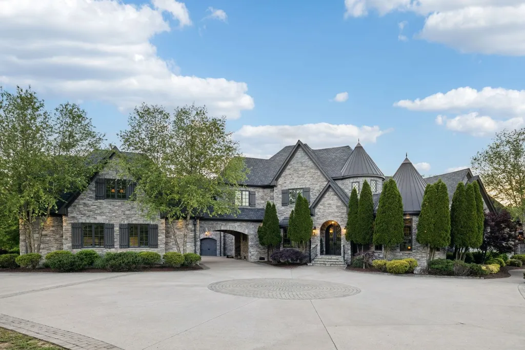 Inside a $12 Million Tennessee Estate With 62 Private Acres and Resort Amenities 1 Exterior view of a private luxury estate in College Grove Tennessee featuring stone architecture, gated driveway, and landscaped grounds