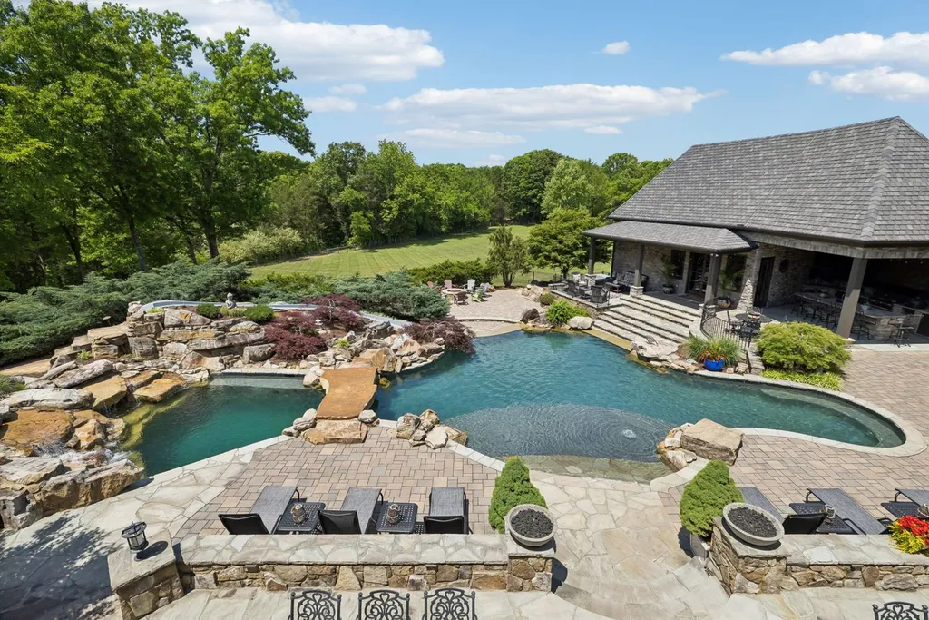 Inside a $12 Million Tennessee Estate With 62 Private Acres and Resort Amenities 15 Luxury pool and outdoor living area at a private estate in College Grove Tennessee featuring stone landscaping, water features, and expansive countryside views