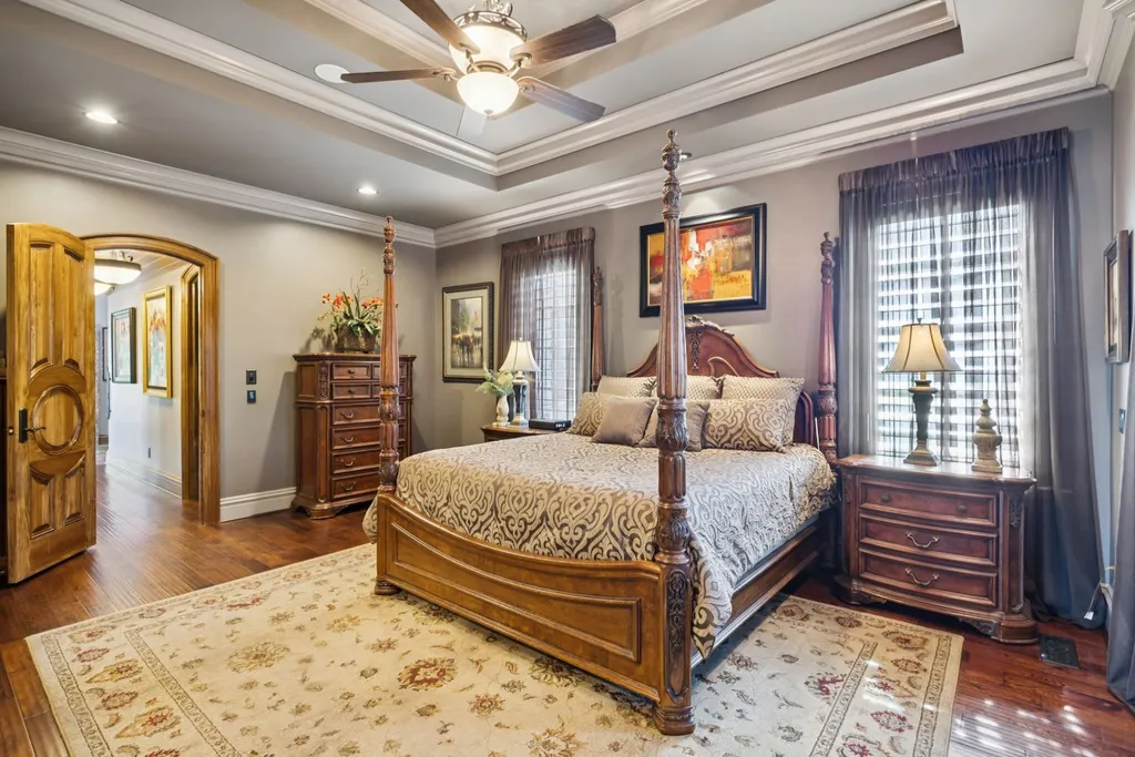 Inside a $12 Million Tennessee Estate With 62 Private Acres and Resort Amenities 4 Primary bedroom inside a luxury estate in College Grove Tennessee featuring hardwood floors, tray ceilings, and classic furnishings