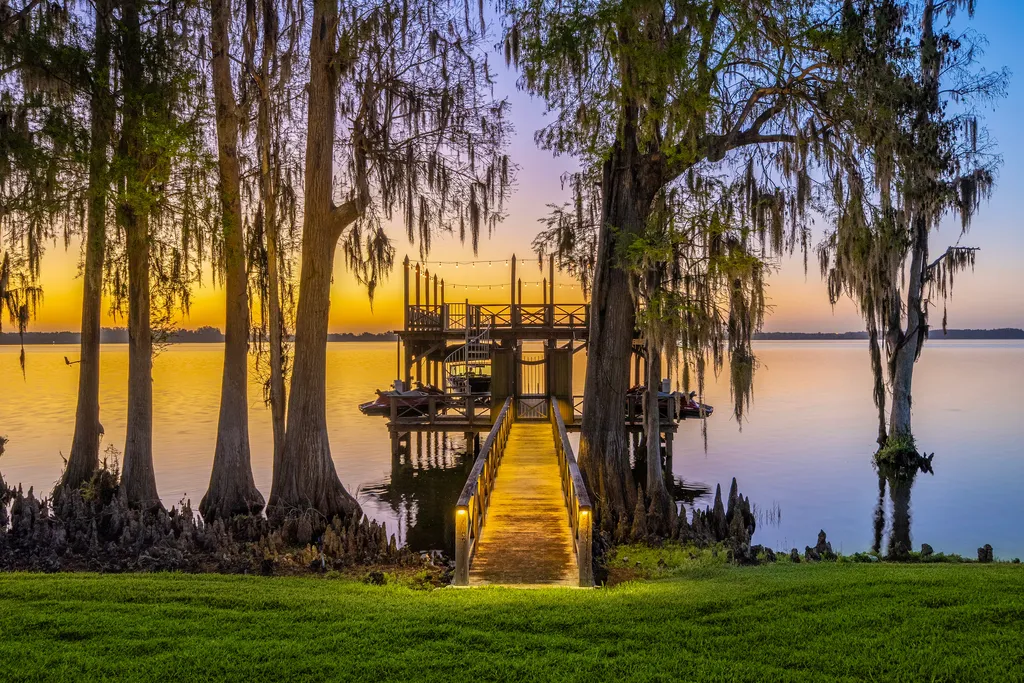 Inside Florida’s Most Ambitious Private Estate: The Oaks Emerges as a $115 Million Benchmark in Tampa Bay 16 Private boathouse at The Oaks Estate overlooking Lake Thonotosassa at sunset in Tampa, Florida