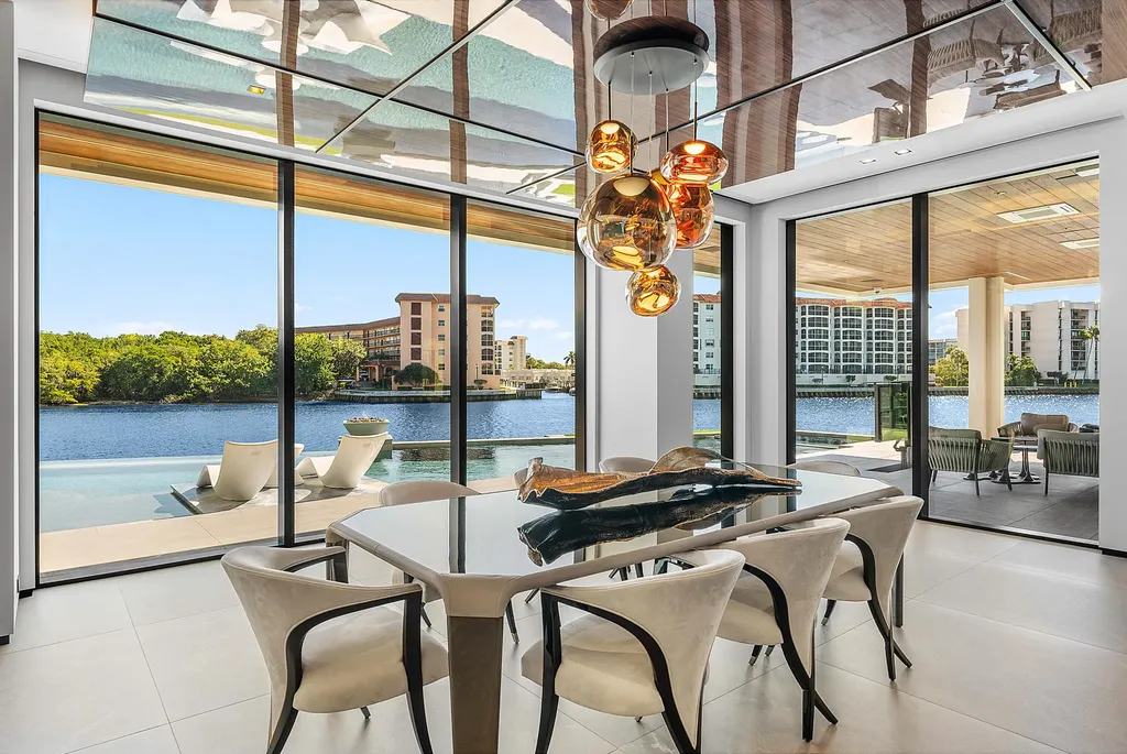 Boca Raton’s Trinity Point Estate Lists for $32.5 Million With 368 Feet of Intracoastal Frontage 5 Luxury waterfront dining room at Trinity Point Estate featuring floor-to-ceiling glass walls overlooking the Intracoastal Waterway