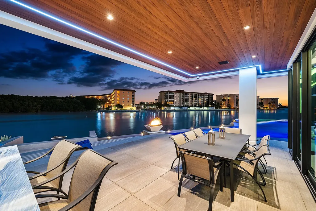 Boca Raton’s Trinity Point Estate Lists for $32.5 Million With 368 Feet of Intracoastal Frontage 8 Covered waterfront terrace at Trinity Point Estate overlooking the Intracoastal Waterway with outdoor dining and fire feature