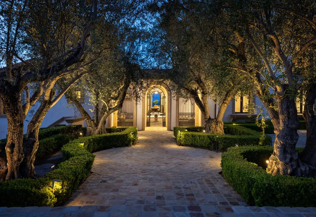 $38,500,000 Shady Canyon Estate in Irvine Blends Contemporary European Design With Nearly an Acre of Privacy 12 Garden courtyard entrance at 76 Golden Eagle in Shady Canyon featuring mature olive trees, illuminated pathways, and estate architecture