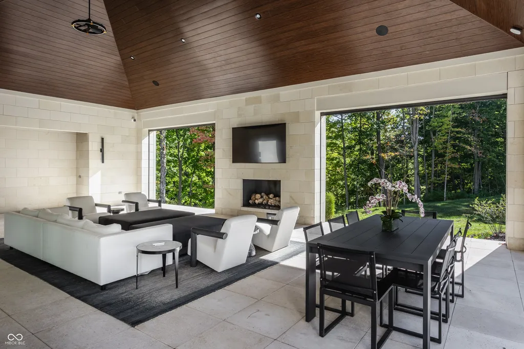 Newly Built $11.9 Million European-Inspired Estate Debuts on 14 Wooded Acres in Carmel, Indiana 7 Covered outdoor living pavilion with fireplace, dining area and lounge overlooking the private wooded grounds of the Carmel luxury estate
