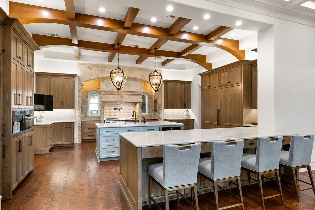 This $11.9 Million Plano Estate Occupies Former Willow Bend Polo Grounds and Spans Nearly Two Acres 8 Gourmet kitchen at the Kings Gate estate in Plano Texas featuring custom cabinetry, oversized island and exposed wood beam ceilings