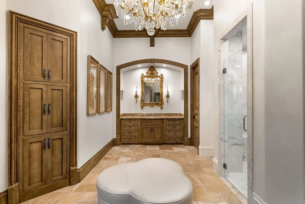 This $11.9 Million Plano Estate Occupies Former Willow Bend Polo Grounds and Spans Nearly Two Acres 10 Luxury primary bathroom suite at the Kings Gate estate in Plano Texas featuring custom cabinetry, crystal chandelier and marble shower