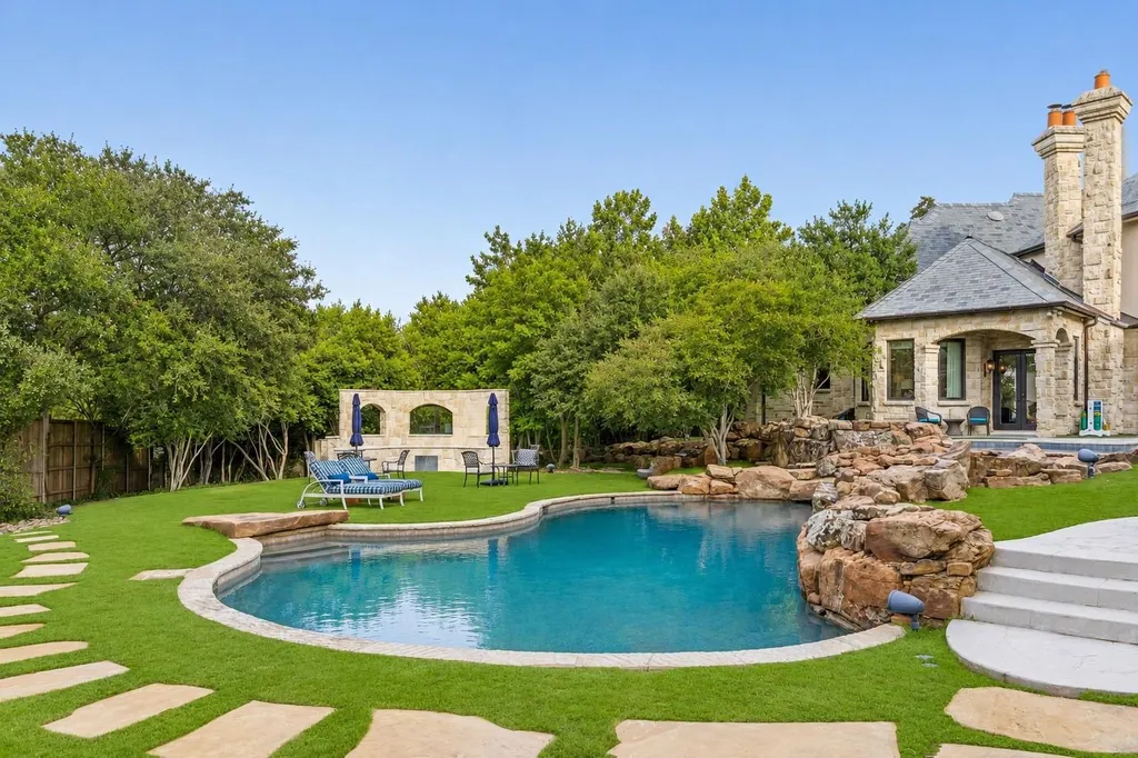 This $11.9 Million Plano Estate Occupies Former Willow Bend Polo Grounds and Spans Nearly Two Acres 13 Resort-style swimming pool at the Kings Gate estate in Plano Texas featuring natural stone waterfalls, landscaped grounds and private outdoor living spaces