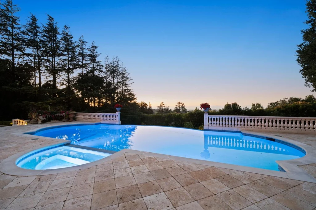 10285 Magdalena Rd – Illuminated Pool Spa 10285 Magdalena Rd, Los Altos Hills: the pool and spa glow against the balustraded terrace at twilight.