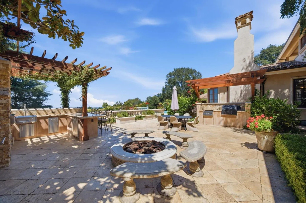 10285 Magdalena Rd – Outdoor Kitchen Terrace 10285 Magdalena Rd, Los Altos Hills: an outdoor kitchen and dining terrace overlook the landscaped grounds.