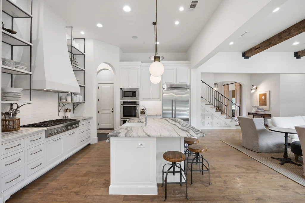 1255 Bolton Ct – Kitchen Cabinetry 1255 Bolton Ct, Southlake: white cabinetry, a substantial range hood and wood floors connect the kitchen with the living spaces.