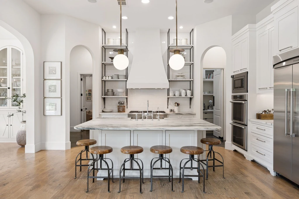 1255 Bolton Ct – Stone Island Kitchen 1255 Bolton Ct, Southlake: veined stone and sculptural pendant lights give the island kitchen a distinctive focal point.