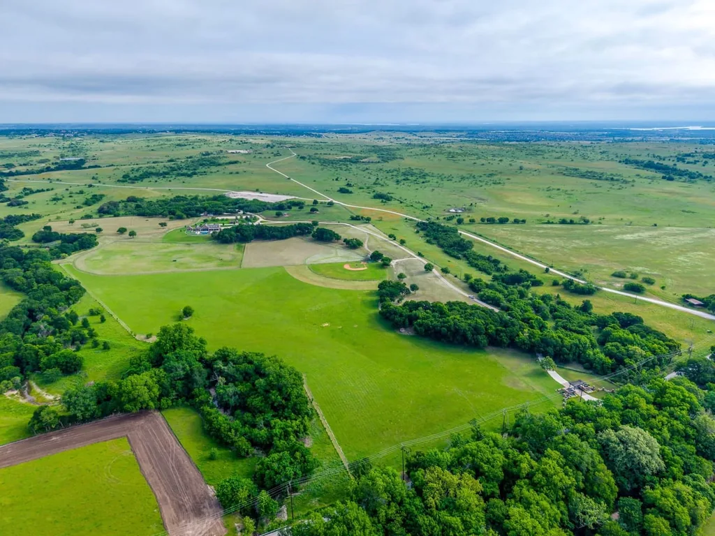 A Texas Estate Built Around Circa-1740 Scottish Timbers Lists for $14,250,000 20 An aerial view shows the scale of the pasture and tree-lined landscape at 13000 Old Weatherford Rd, Aledo