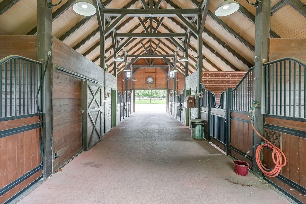 A Texas Estate Built Around Circa-1740 Scottish Timbers Lists for $14,250,000 17 The barn’s central aisle runs between stalls beneath exposed roof trusses at 13000 Old Weatherford Rd, Aledo
