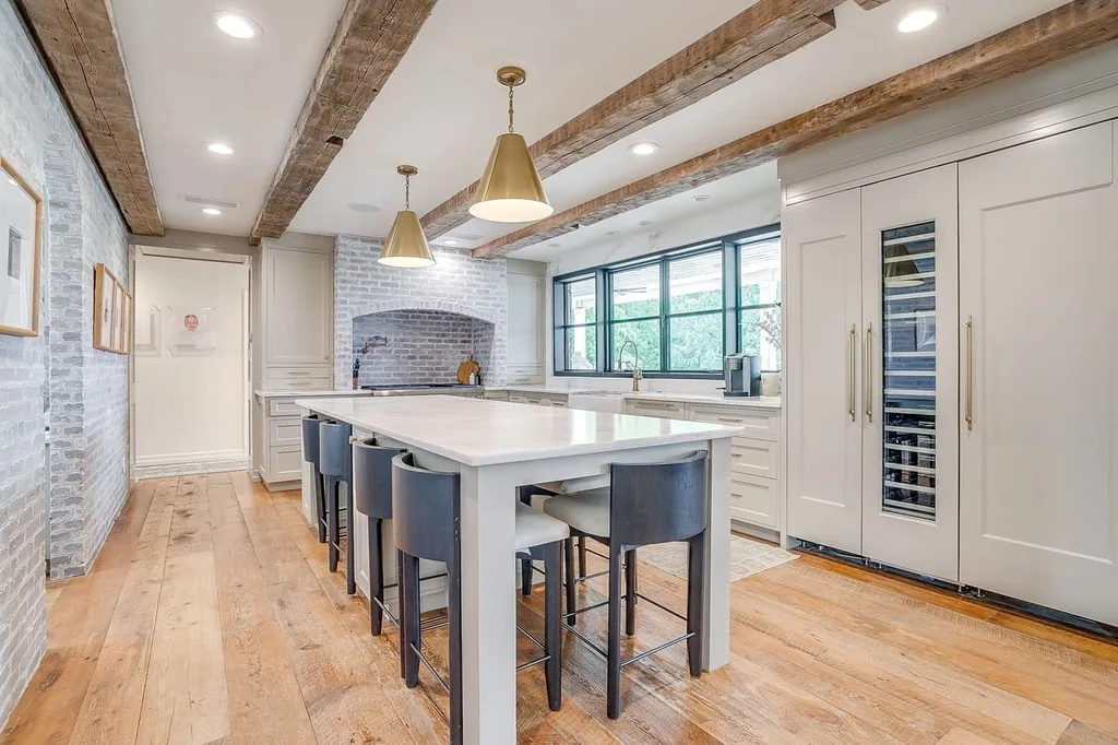 A Texas Estate Built Around Circa-1740 Scottish Timbers Lists for $14,250,000 6 Pale cabinetry and an island keep the kitchen connected to the home’s timber palette at 13000 Old Weatherford Rd, Aledo