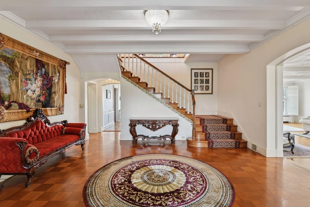 1305 Shoreline Dr — Entrance Hall Staircase The entrance hall introduces hardwood floors, ceiling beams and a sweeping staircase at 1305 Shoreline Dr.