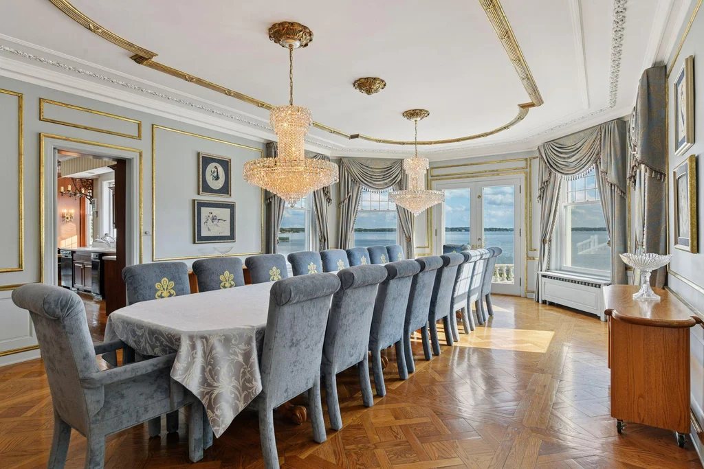 1305 Shoreline Dr — Formal Dining Room A long dining table sits beneath a curved ceiling treatment and chandelier at 1305 Shoreline Dr.