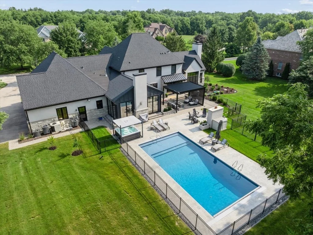Inverness Estate With a Speakeasy-Style Lounge and Indoor Golf Simulator Lists for $2,750,000 19 Aerial view of the pool, pergola and lawn behind the Inverness home