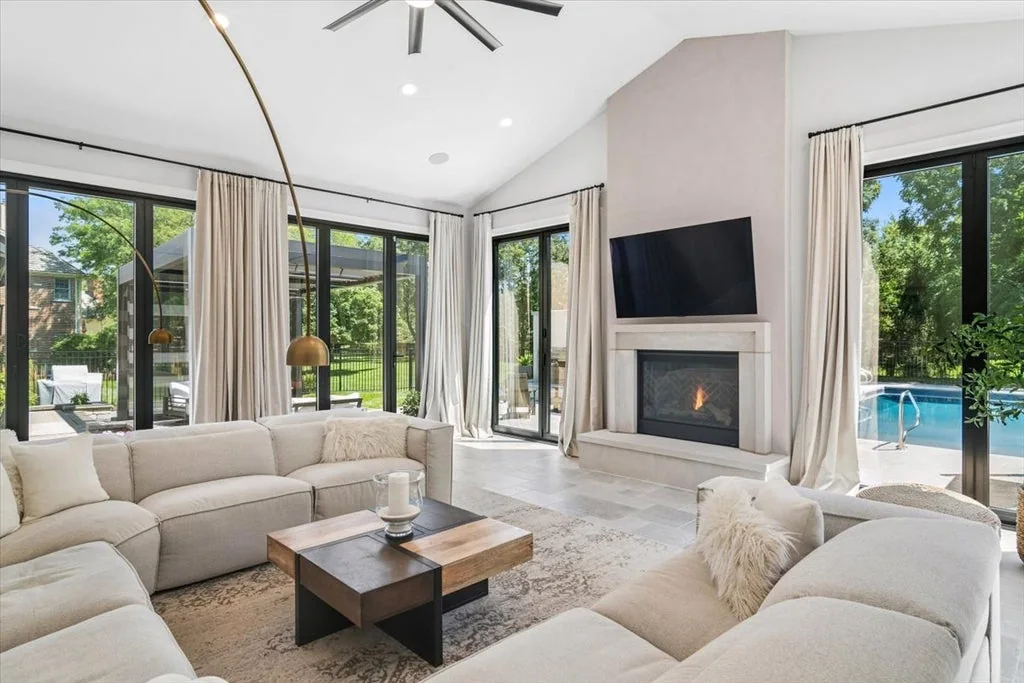 Inverness Estate With a Speakeasy-Style Lounge and Indoor Golf Simulator Lists for $2,750,000 7 Family room with a fireplace and glass doors overlooking the pool in Inverness, Illinois