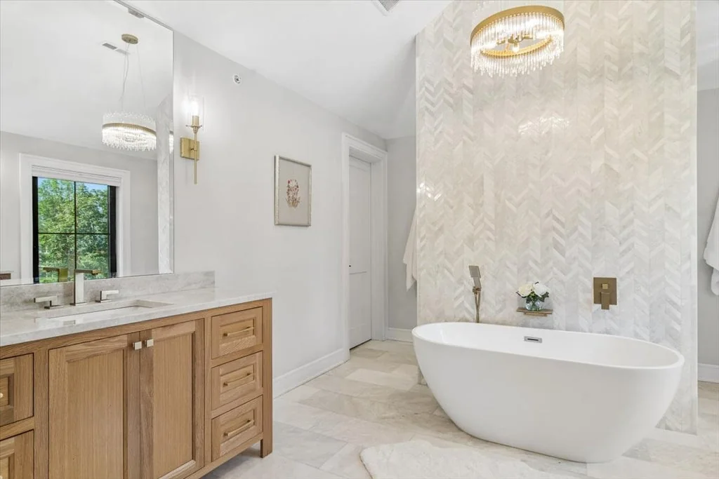 Inverness Estate With a Speakeasy-Style Lounge and Indoor Golf Simulator Lists for $2,750,000 14 Freestanding bathtub with wood vanities and brass-toned fittings in Inverness, Illinois
