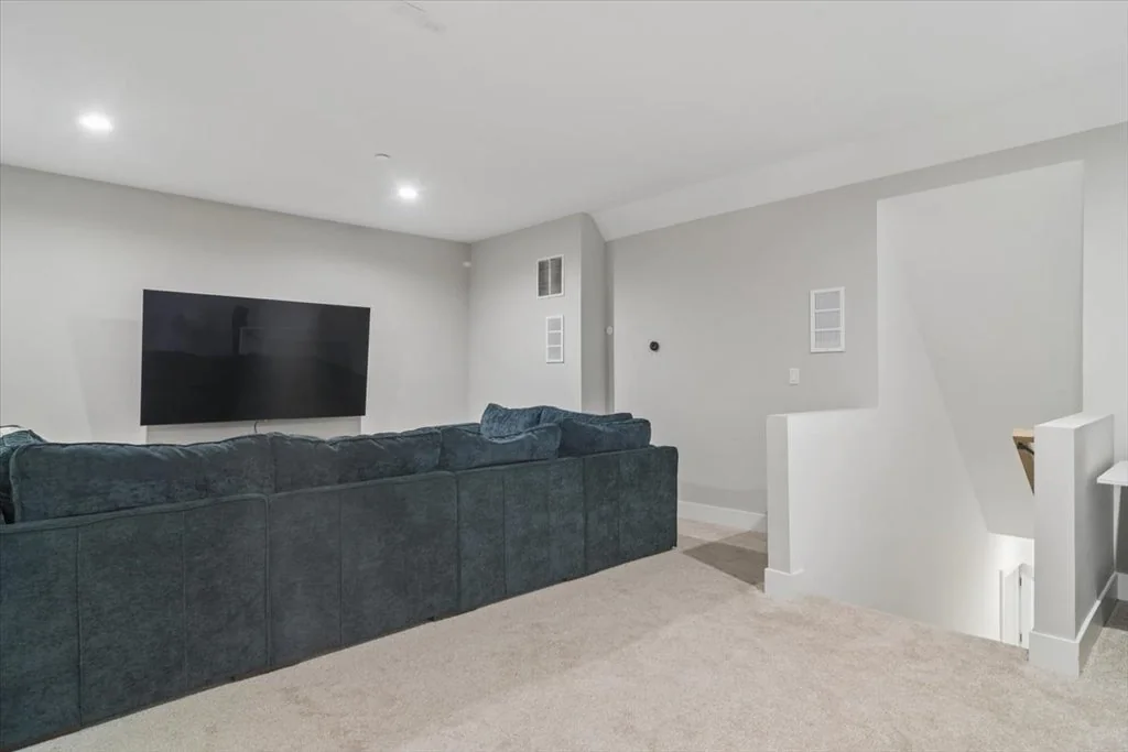 Inverness Estate With a Speakeasy-Style Lounge and Indoor Golf Simulator Lists for $2,750,000 15 Media room with a large sectional sofa and wall-mounted television in Inverness, Illinois