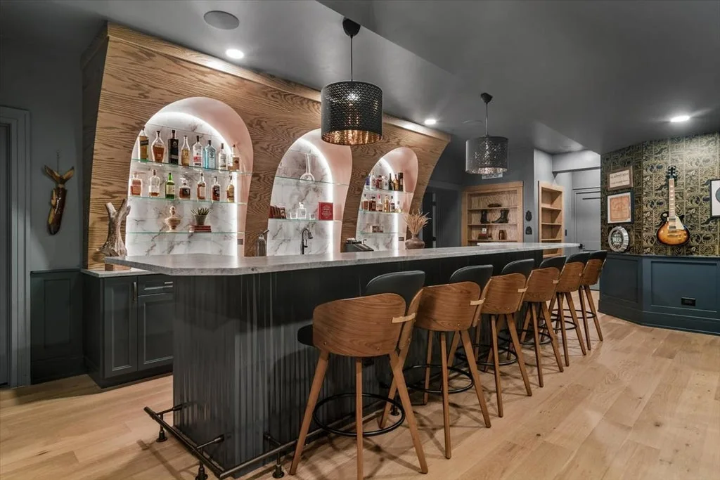 Inverness Estate With a Speakeasy-Style Lounge and Indoor Golf Simulator Lists for $2,750,000 9 Lower-level bar with illuminated arched niches and upholstered stools in Inverness, Illinois