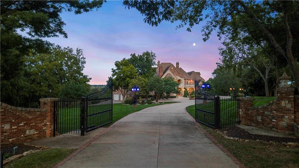 Leawood Estate Bordered by Ironwoods Park on Two Sides Asks $6,500,000 17 The gated driveway frames the approach at dusk at 14707 Mission Rd, Leawood