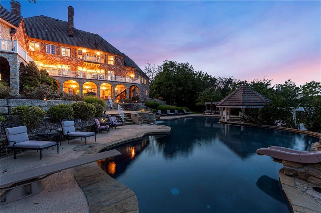 Leawood Estate Bordered by Ironwoods Park on Two Sides Asks $6,500,000 19 The pool terrace takes on a different atmosphere at twilight at 14707 Mission Rd, Leawood