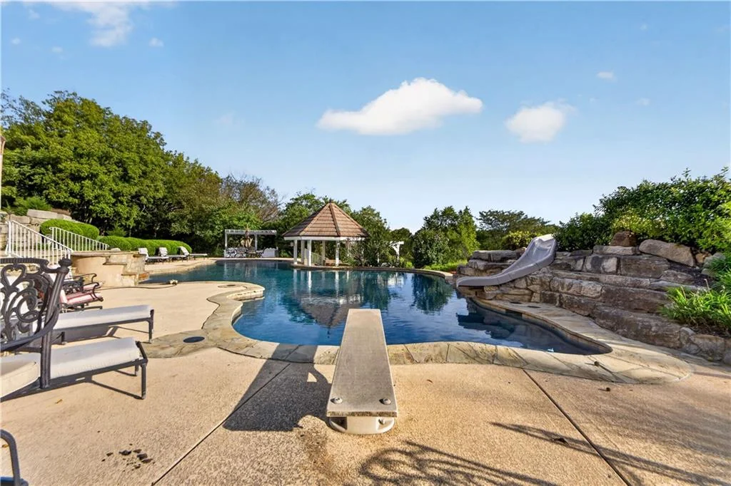 Leawood Estate Bordered by Ironwoods Park on Two Sides Asks $6,500,000 12 Stone paving provides space for lounging beside the water at 14707 Mission Rd, Leawood