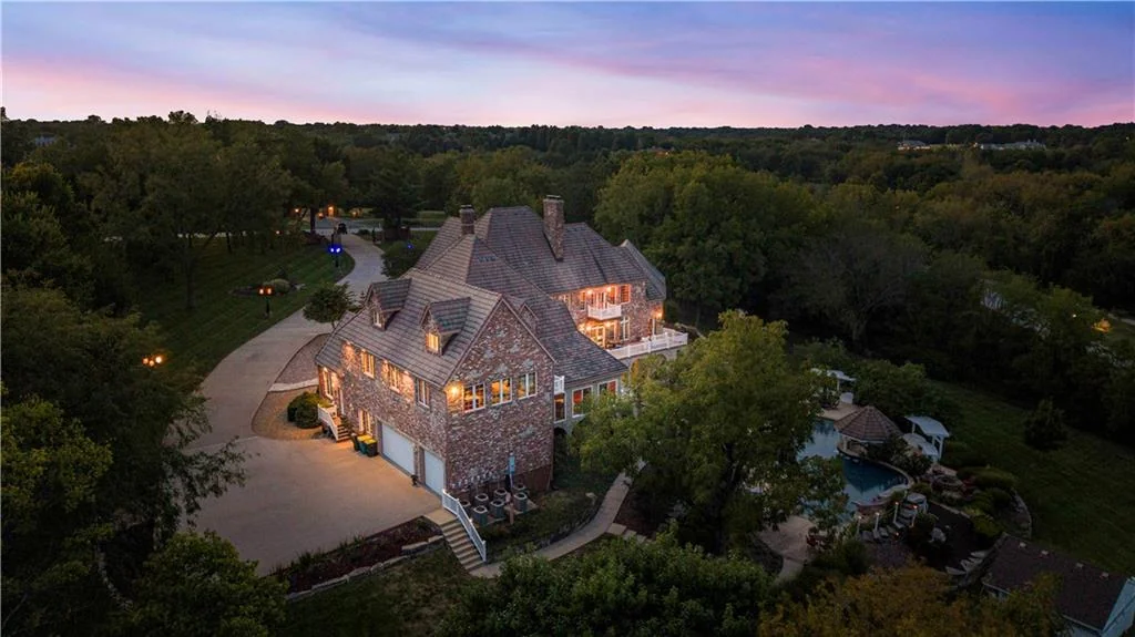 Leawood Estate Bordered by Ironwoods Park on Two Sides Asks $6,500,000 20 A twilight view reveals the rear balconies and arched lower level at 14707 Mission Rd, Leawood
