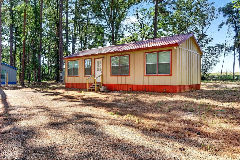 16104 County Road 294 – Red Trim Woodland Cabin 16104 County Road 294, Arp: a furnished cabin with red trim sits beneath tall trees.