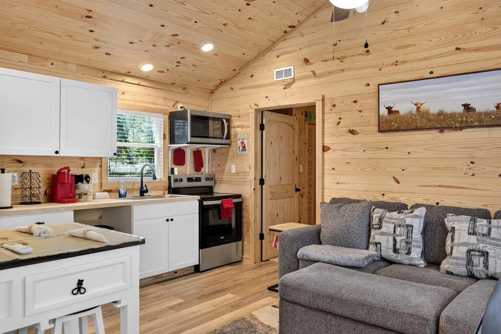 16104 County Road 294 – Cabin Kitchen and Living Room 16104 County Road 294, Arp: timber finishes connect a cabin kitchen with its compact living area.