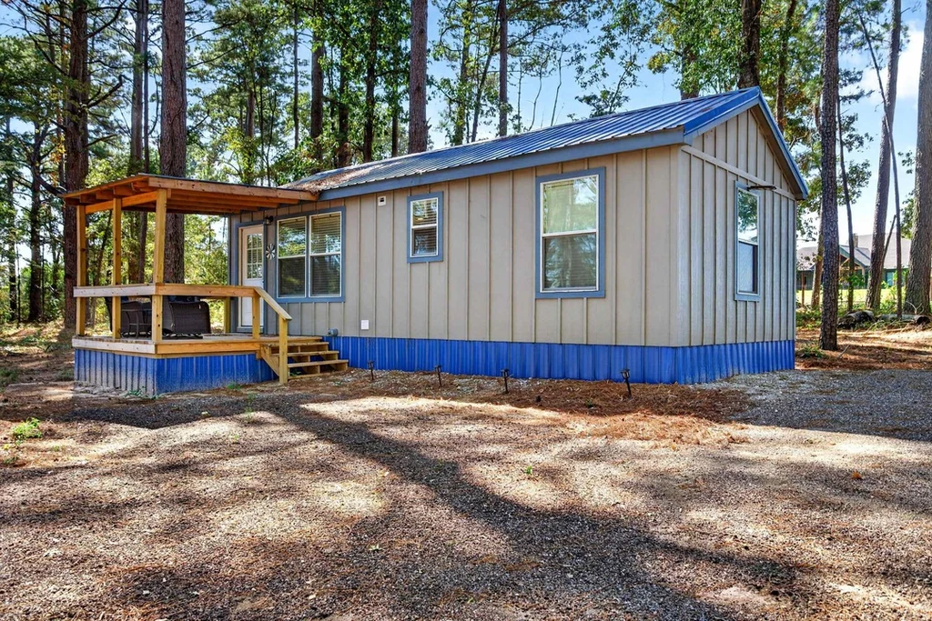 16104 County Road 294 – Blue Trim Woodland Cabin 16104 County Road 294, Arp: a blue trimmed cabin has a covered porch overlooking the trees.