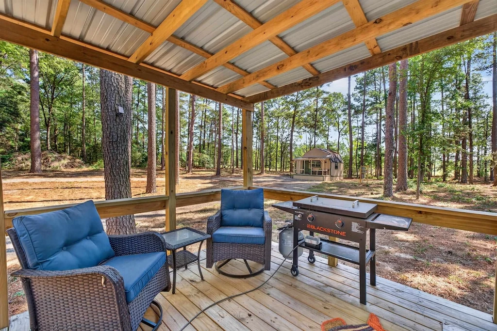 16104 County Road 294 – Cabin Covered Porch 16104 County Road 294, Arp: a covered cabin porch provides seating and a grill in the woodland setting.