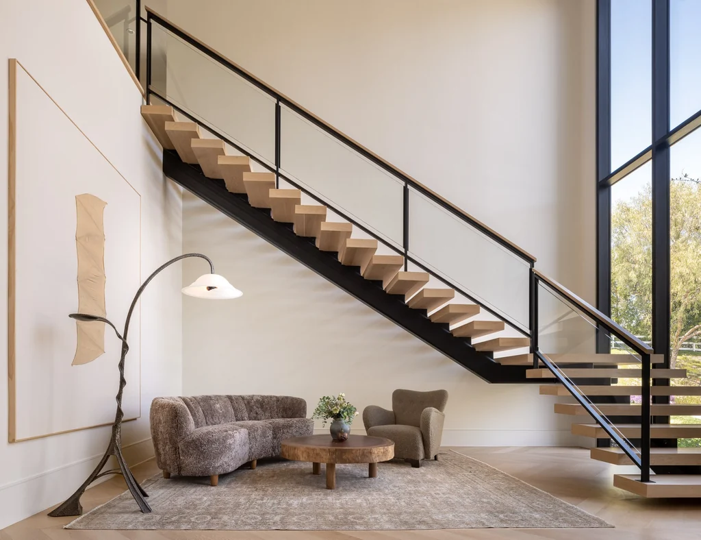 25211 Jim Bridger Rd – Floating Staircase 25211 Jim Bridger Rd, Hidden Hills: a floating staircase rises beside tall windows in the entrance hall.