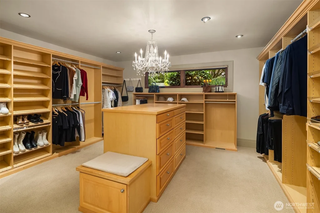 Pocket Doors Open to a Lake-View Pavilion at This Sammamish Estate Asking $6,880,000 13 Dressing room with wood shelving, central island and chandelier