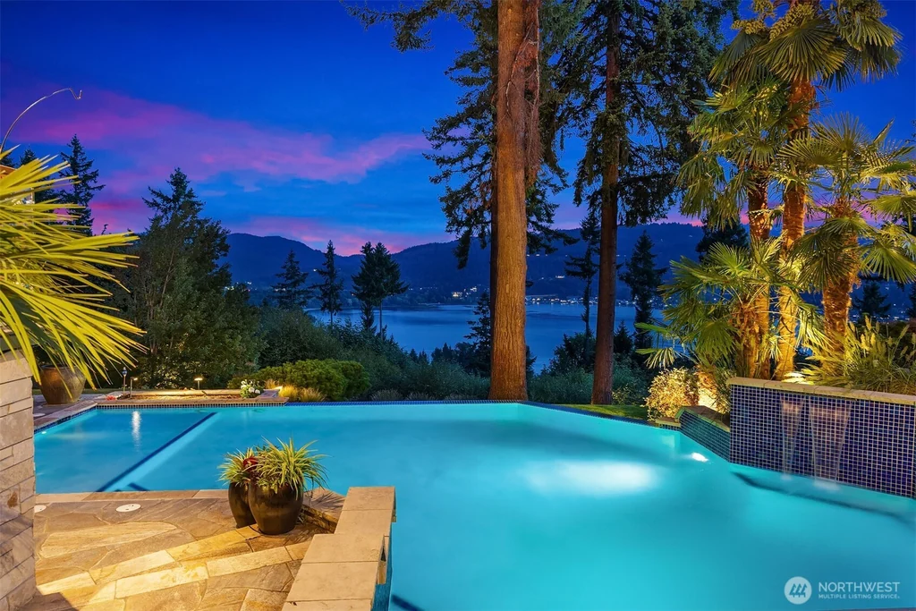 Pocket Doors Open to a Lake-View Pavilion at This Sammamish Estate Asking $6,880,000 18 Heated pool with rock water features and a view toward Lake Sammamish