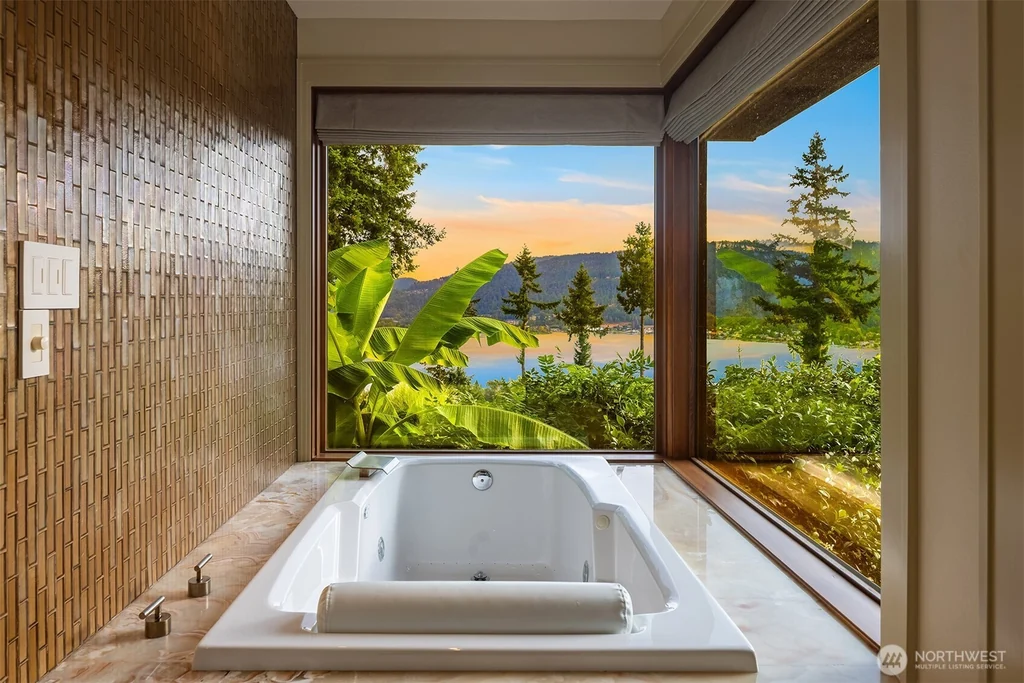 Pocket Doors Open to a Lake-View Pavilion at This Sammamish Estate Asking $6,880,000 12 Recessed soaking tub beneath a picture window overlooking the lake