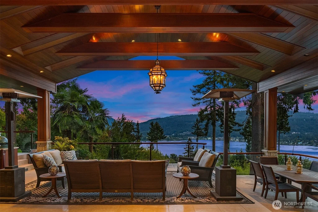 Pocket Doors Open to a Lake-View Pavilion at This Sammamish Estate Asking $6,880,000 9 Timber-framed covered pavilion with dining furniture and a lake view