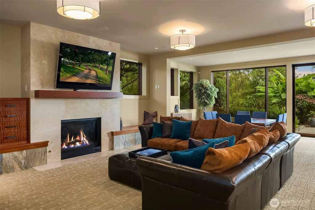 Pocket Doors Open to a Lake-View Pavilion at This Sammamish Estate Asking $6,880,000 16 Lower-level media lounge with a fireplace, television and sectional sofa