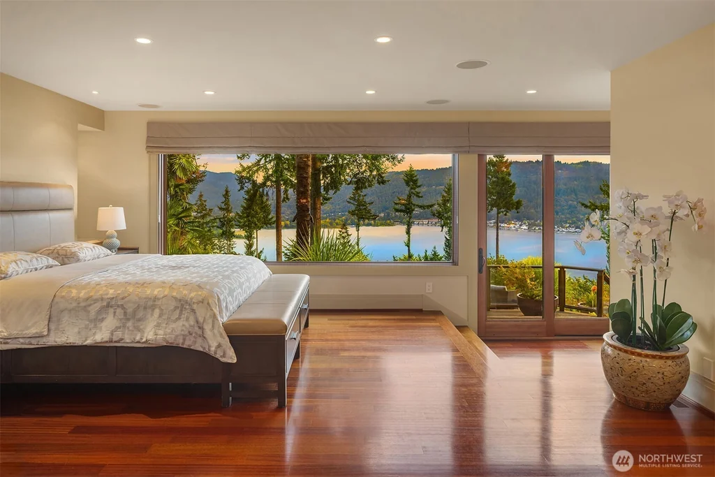Pocket Doors Open to a Lake-View Pavilion at This Sammamish Estate Asking $6,880,000 11 Main-floor primary bedroom with wood flooring and lake-facing windows